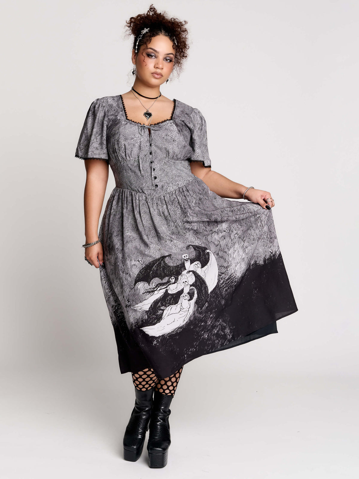 short-sleeved gray and black gothic-style midi dress with a printed illustration of a woman and winged figure at the hem