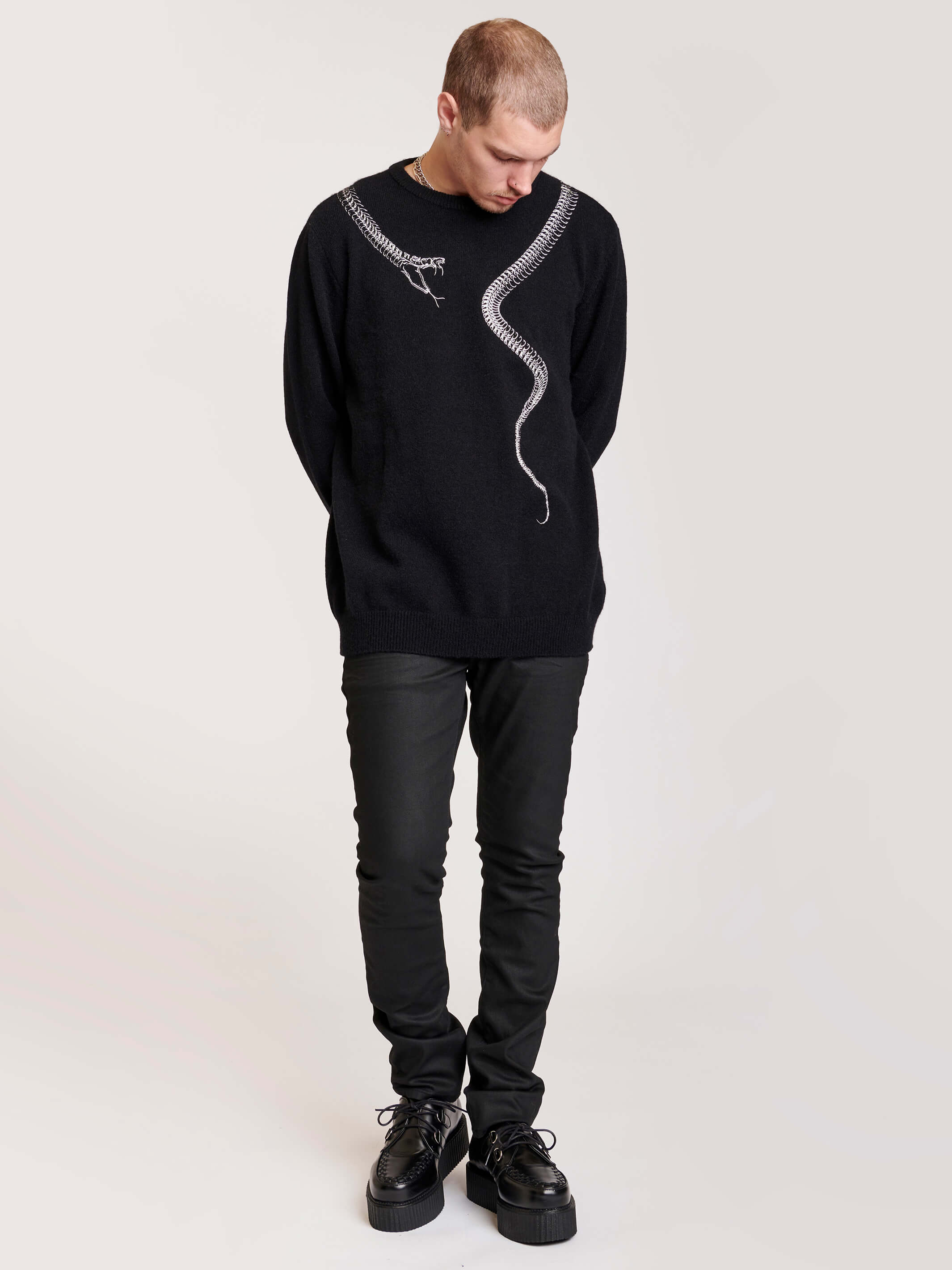 sweater with skeleton snake detail around neck.