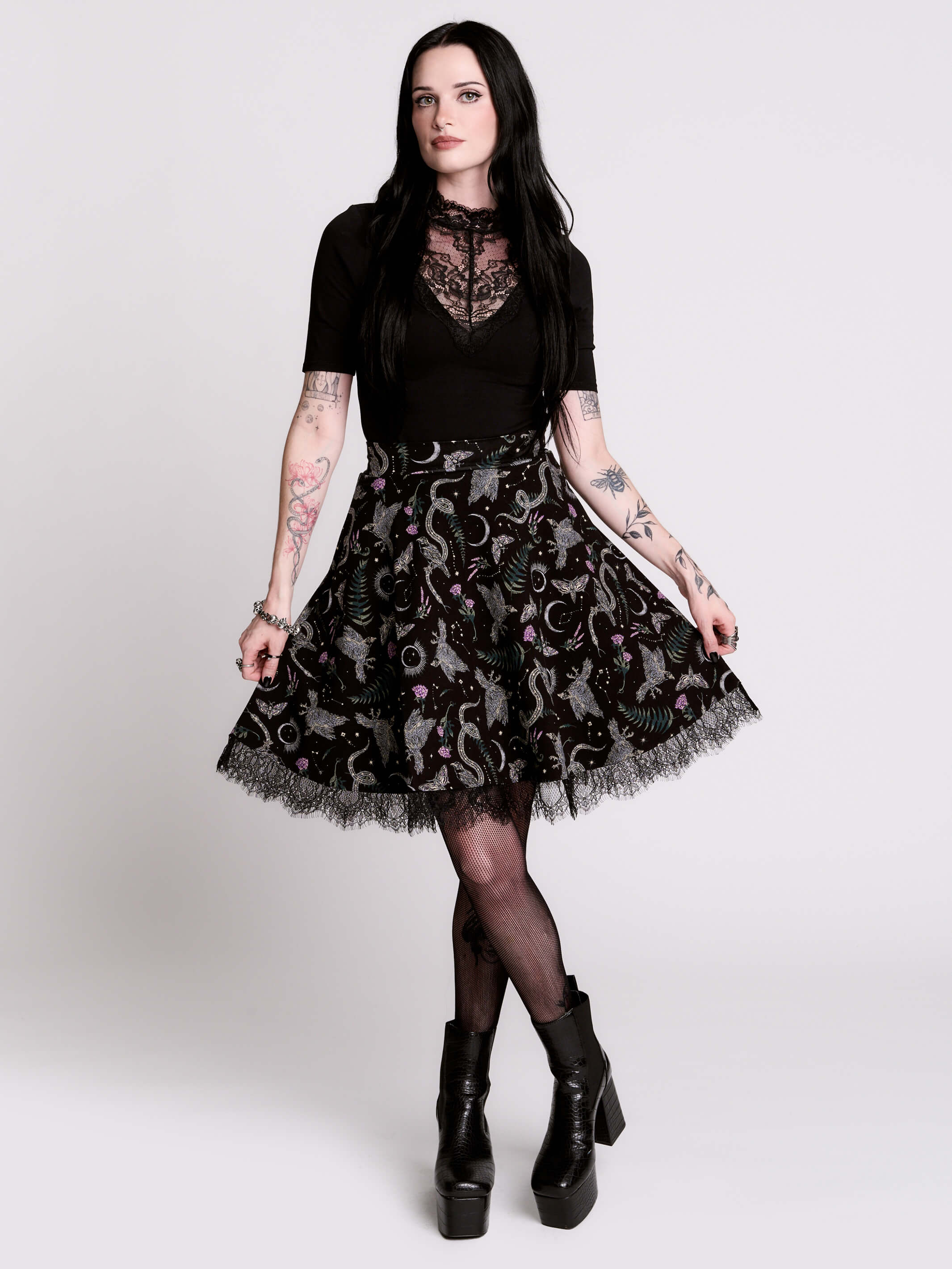 A black flared skirt featuring a gray and purple gothic print with lace hem.