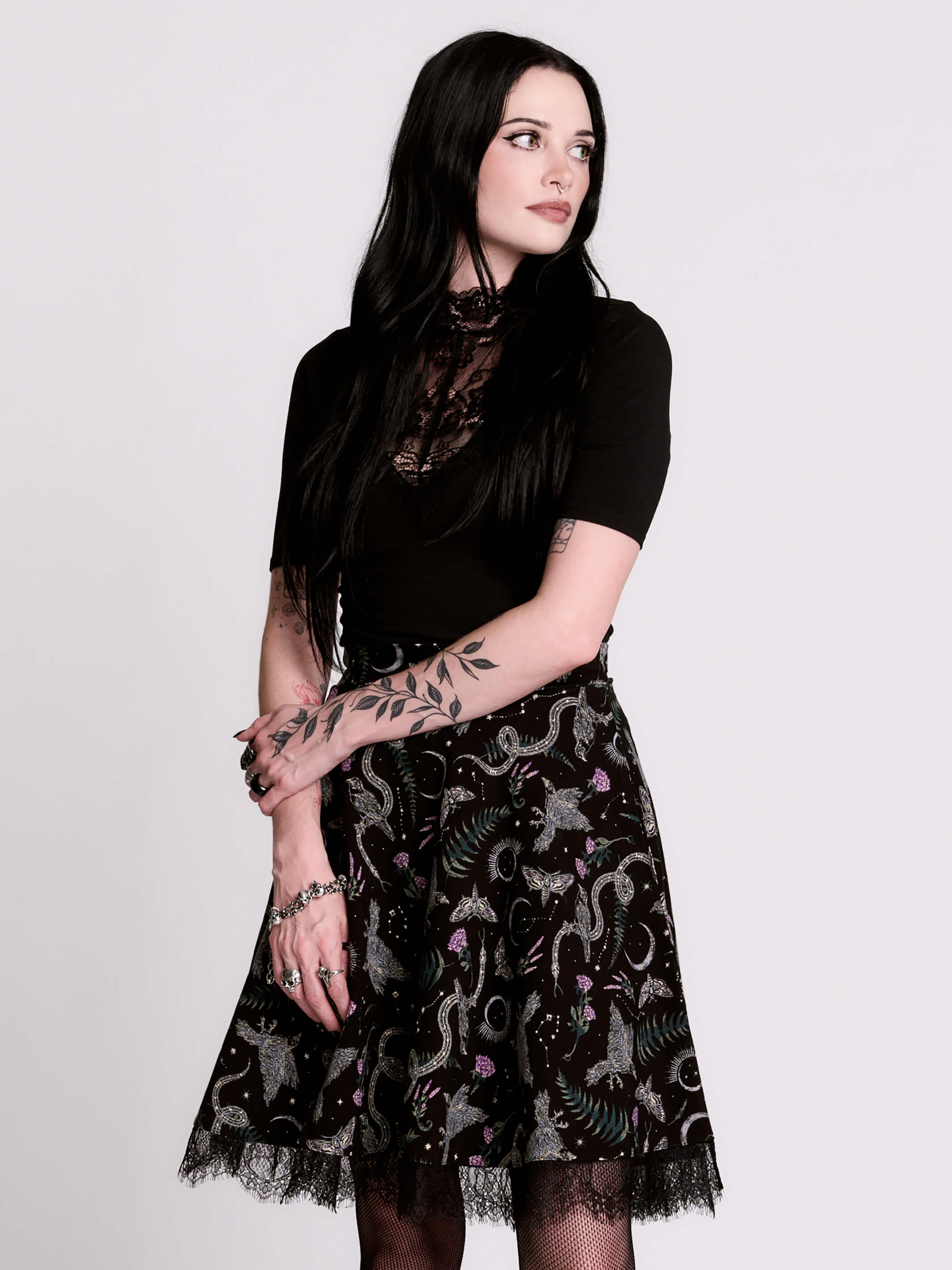 A black flared skirt featuring a gray and purple gothic print with lace hem.
