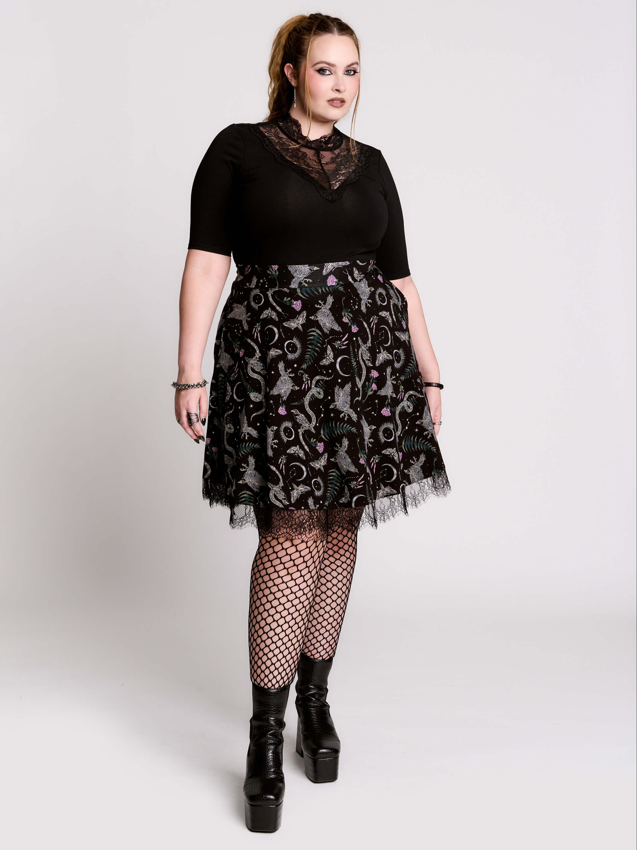 A black flared skirt featuring a gray and purple gothic print with lace hem.