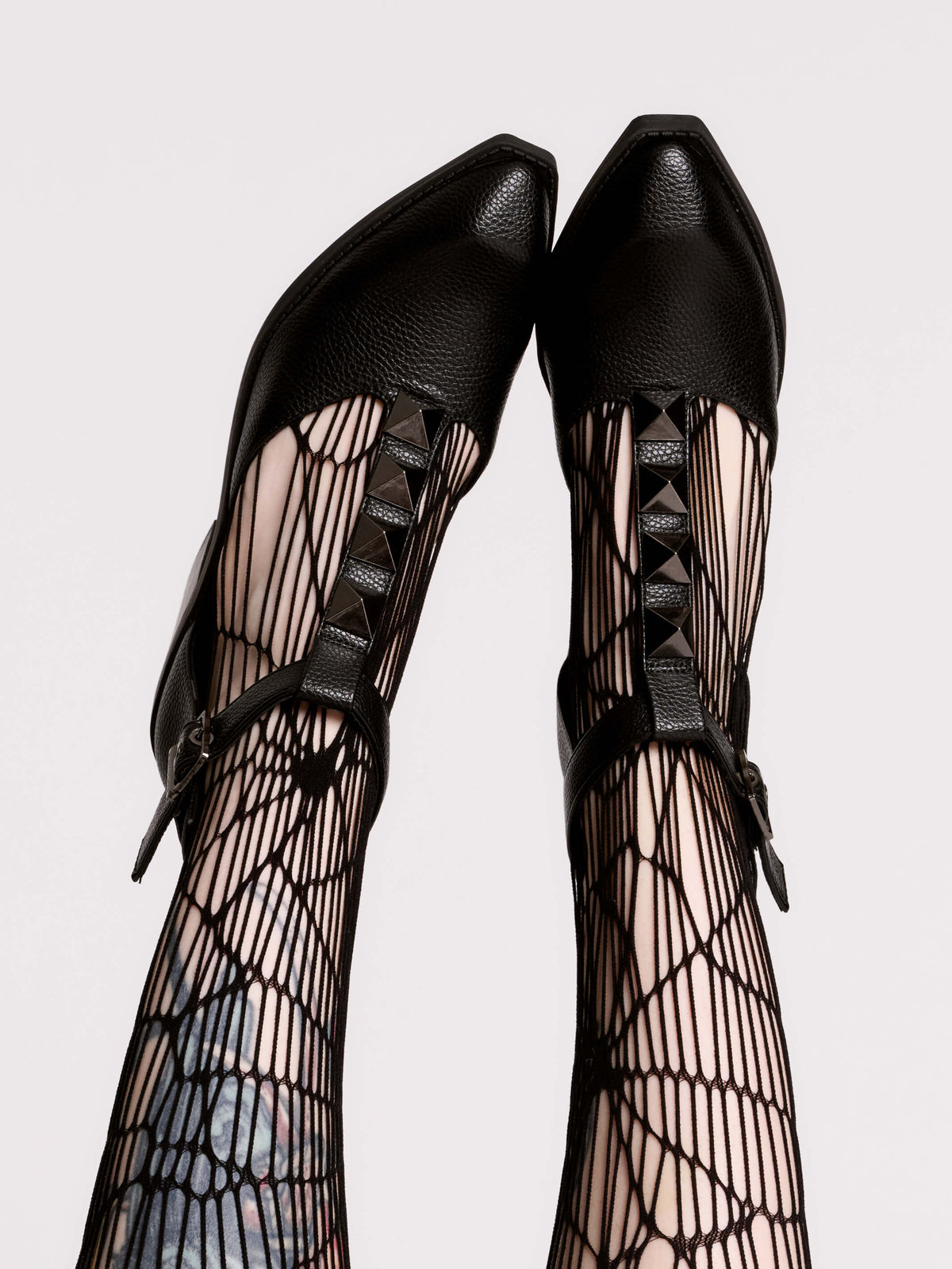 A pair of black leather ankle-strap block-heel shoes with pointed toes and silver pyramid stud embellishments.