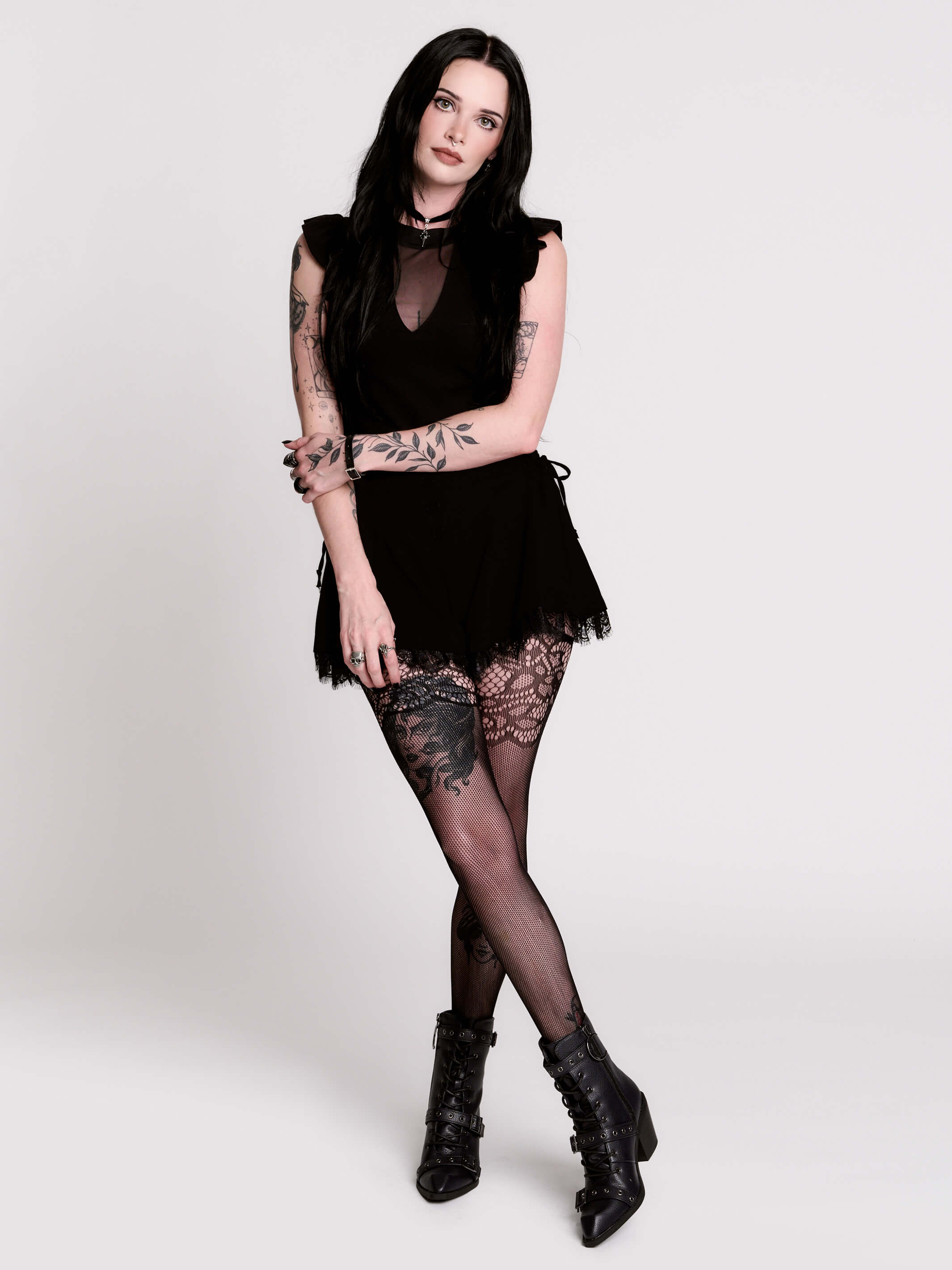 A black ruffled sleeveless top with a sheer chest cutout.