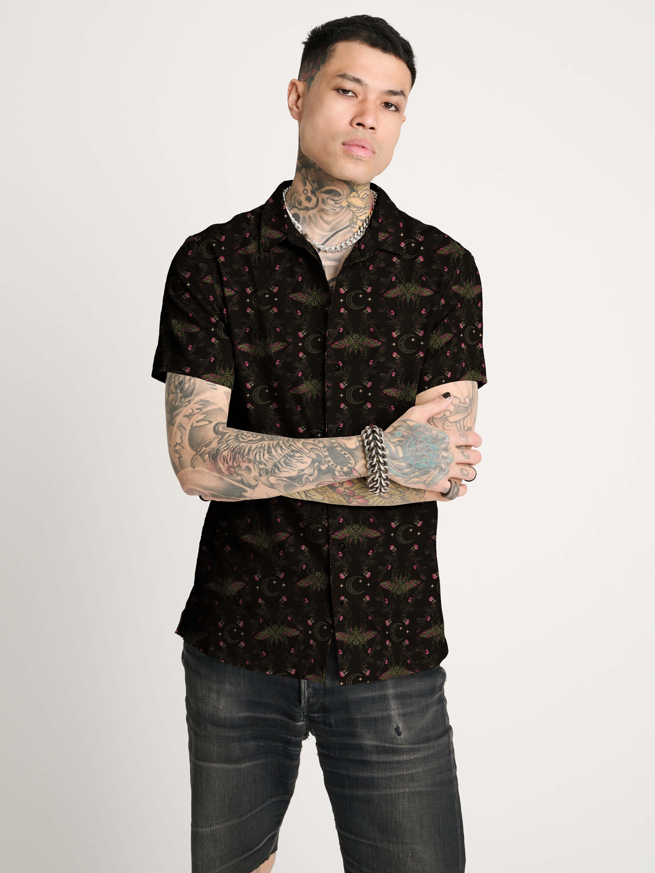 A black short-sleeve button-up shirt with repeating red and green scarab beetle pattern.