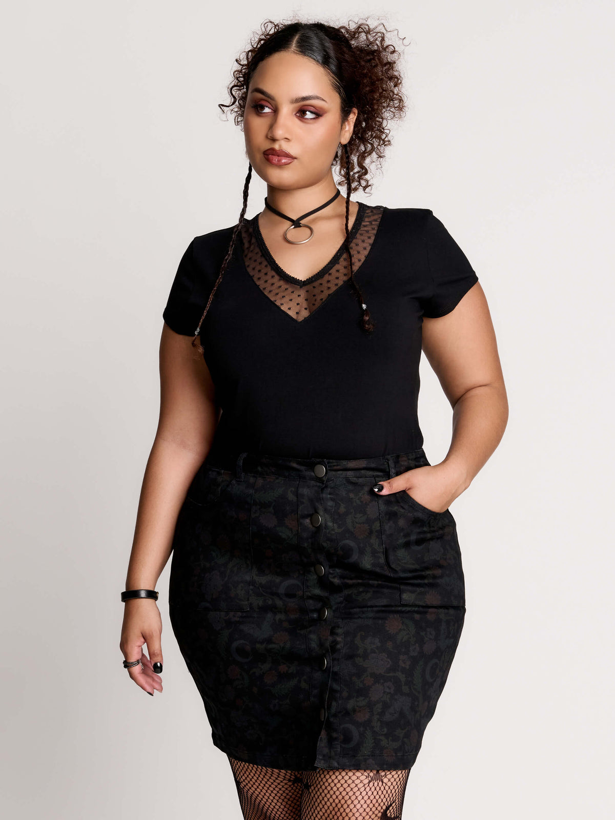 a black short-sleeve V-neck t-shirt featuring a sheer polka-dot mesh panel at the neckline