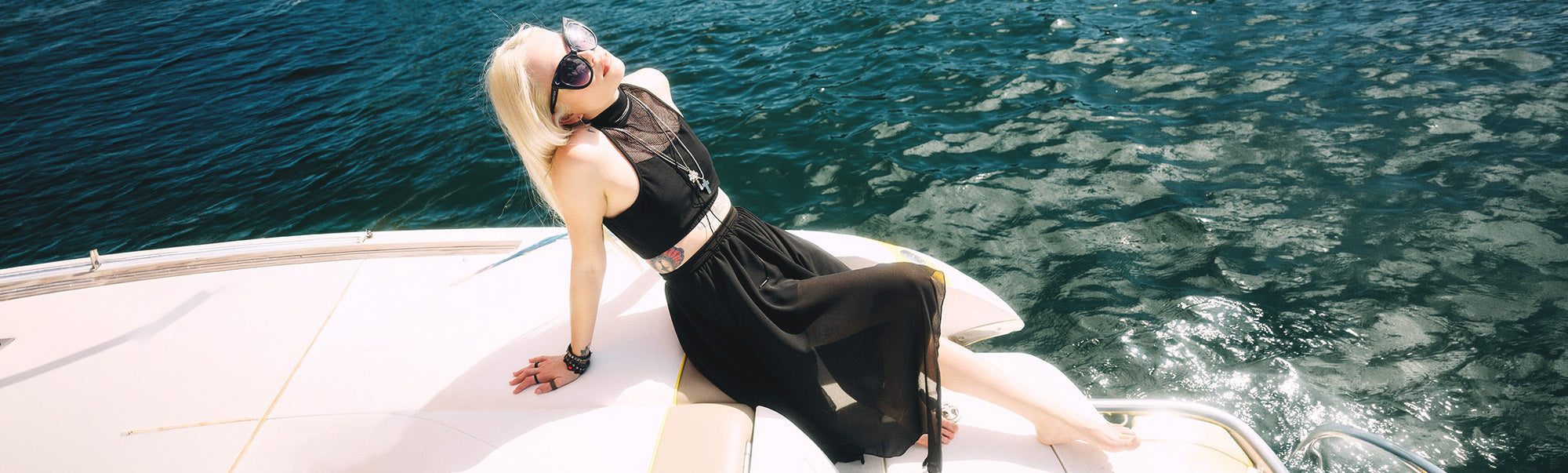 woman in goth clothing enjoying summer on a boat