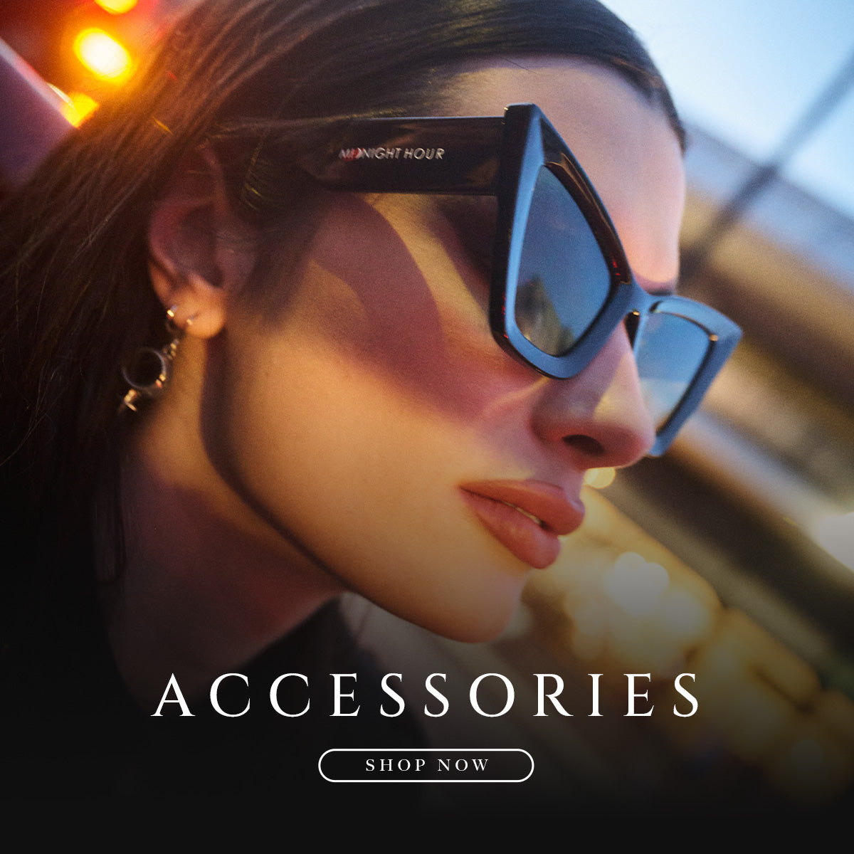 A close-up lifestyle shot of a woman wearing angular cat-eye sunglasses with dark blue frames and dark lenses. The brand name 'MIDNIGHT HOUR' is printed on the temple.