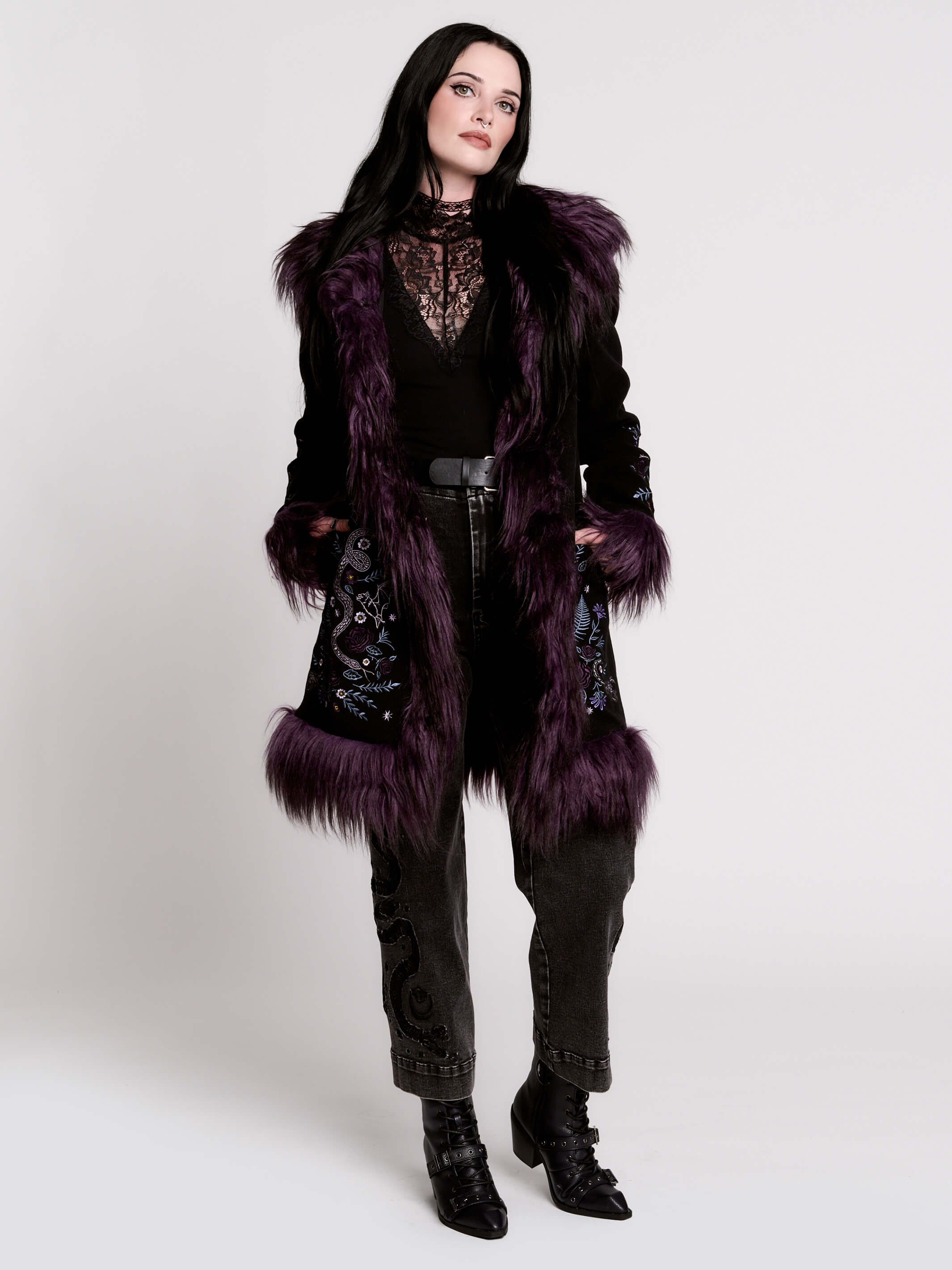 This mid-length black coat pairs a soft, suede-like finish with plush amethyst-purple faux fur trim