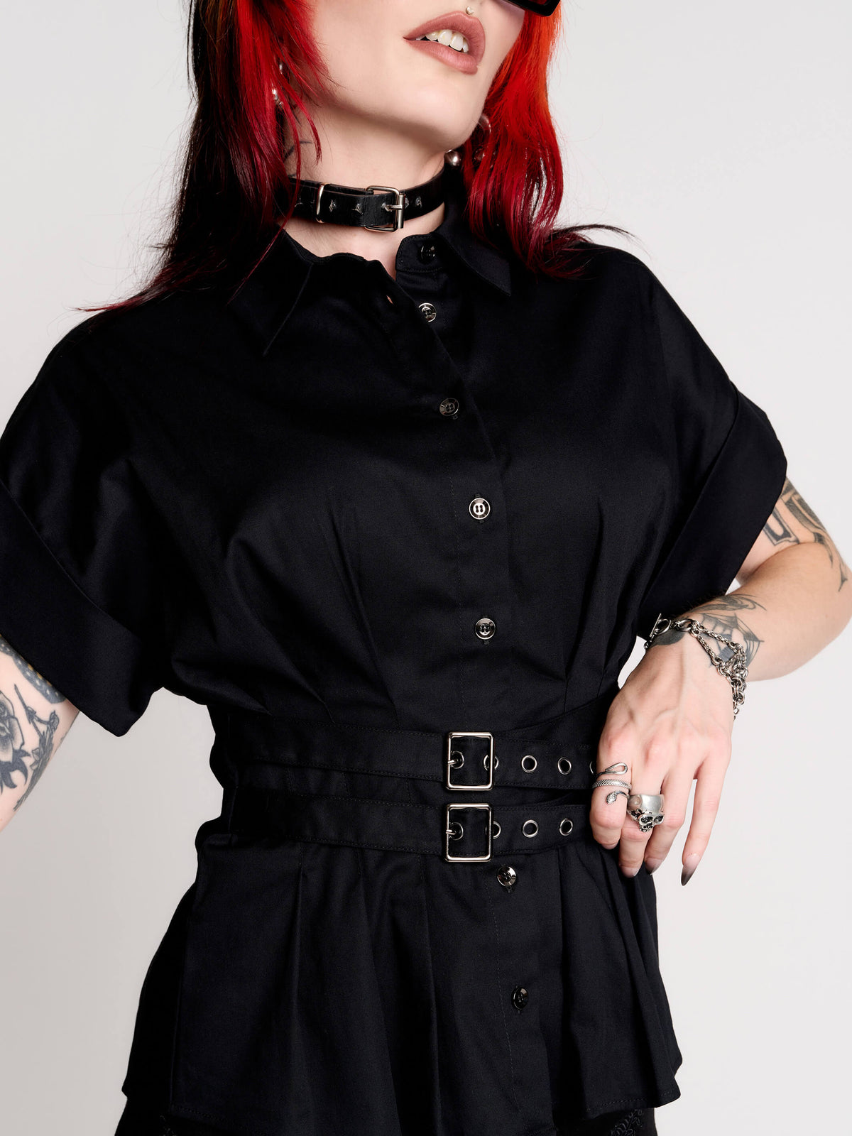 a black short-sleeve button-front shirt dress with a matching double-buckle front waist details.