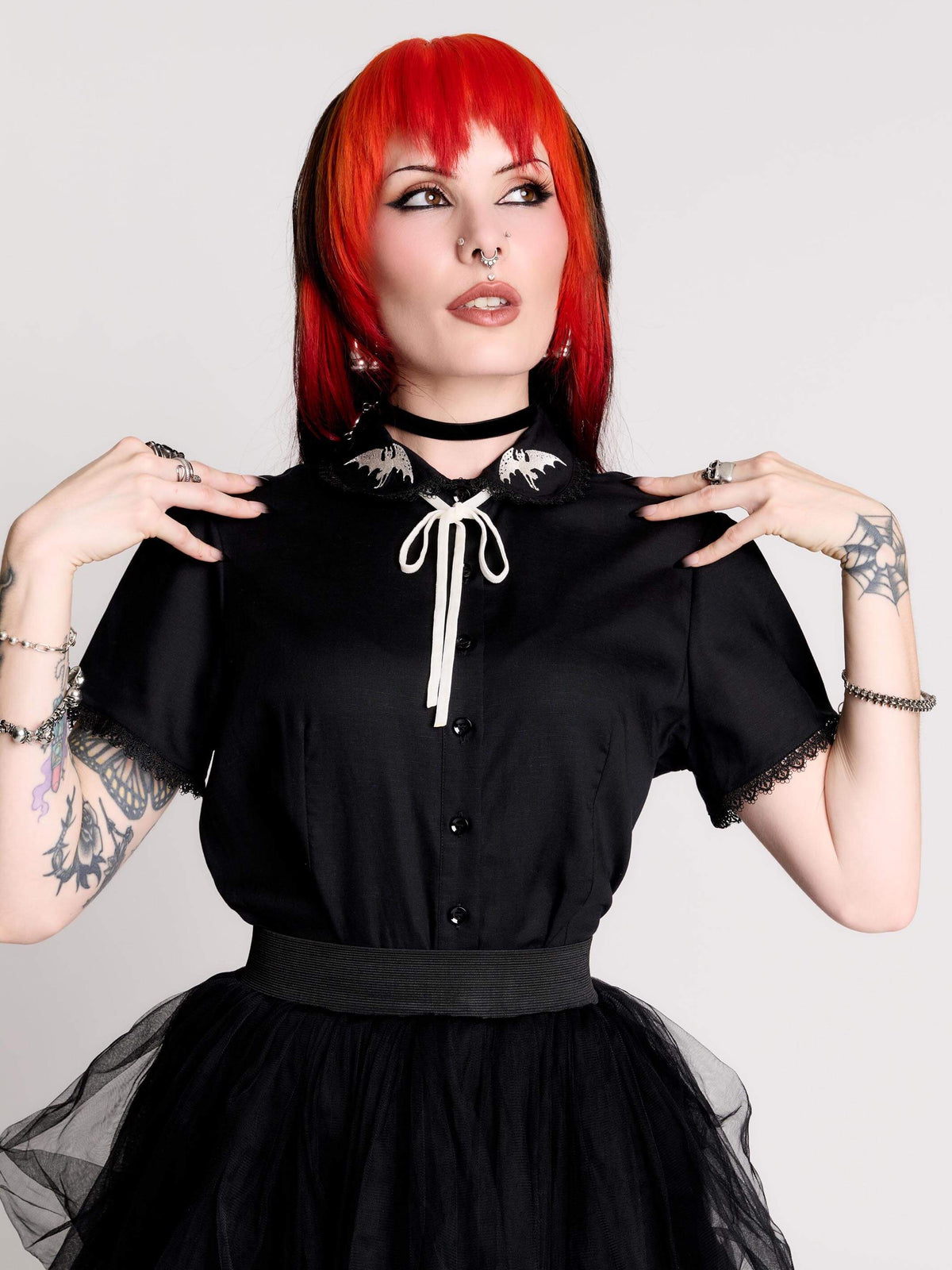 black short-sleeve blouse with white embroidered bat on collar and black lace trim