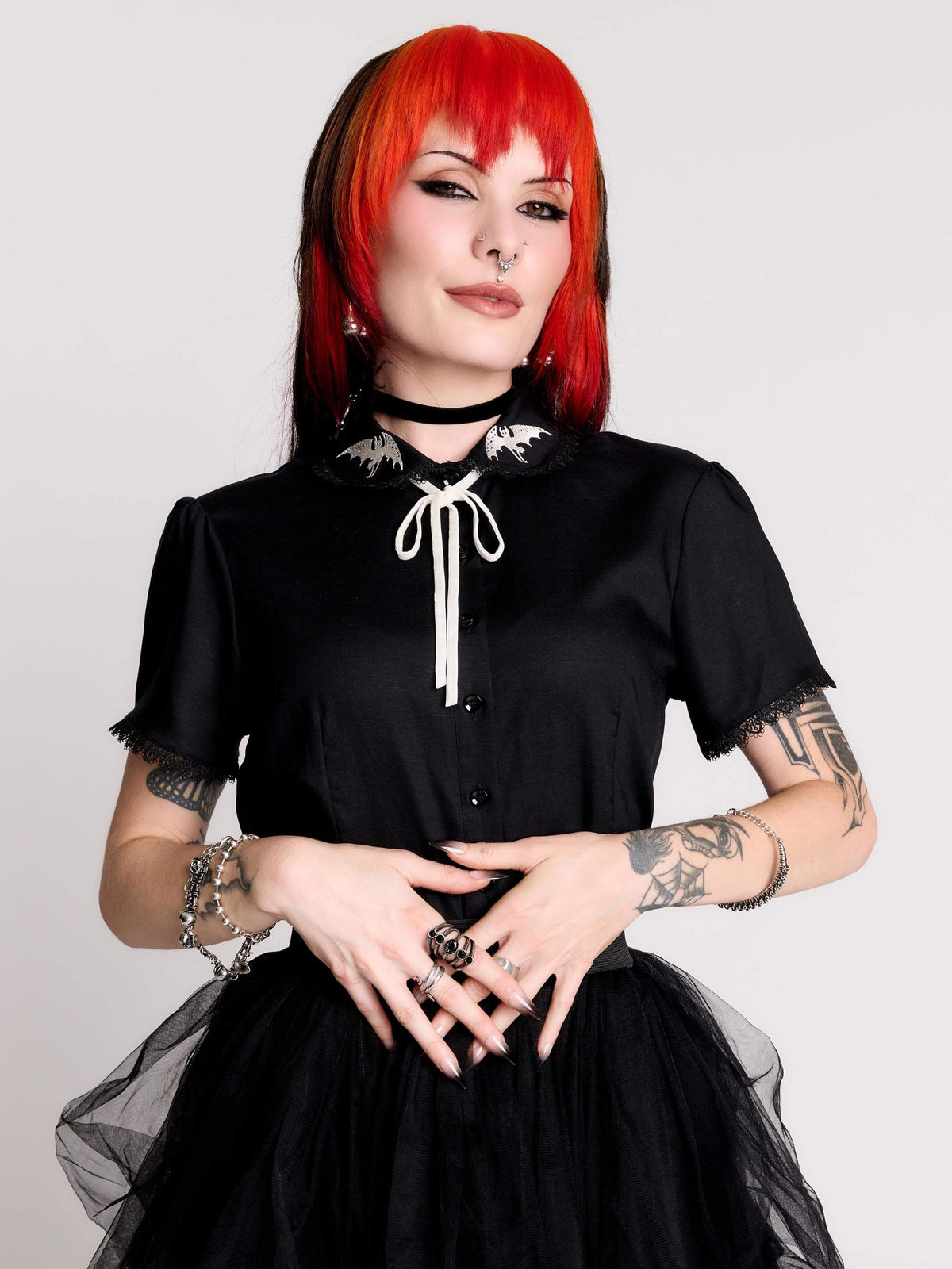 black short-sleeve blouse with white embroidered bat on collar and black lace trim