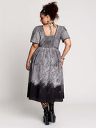short-sleeved gray and black gothic-style midi dress with a printed illustration of a woman and winged figure at the hem