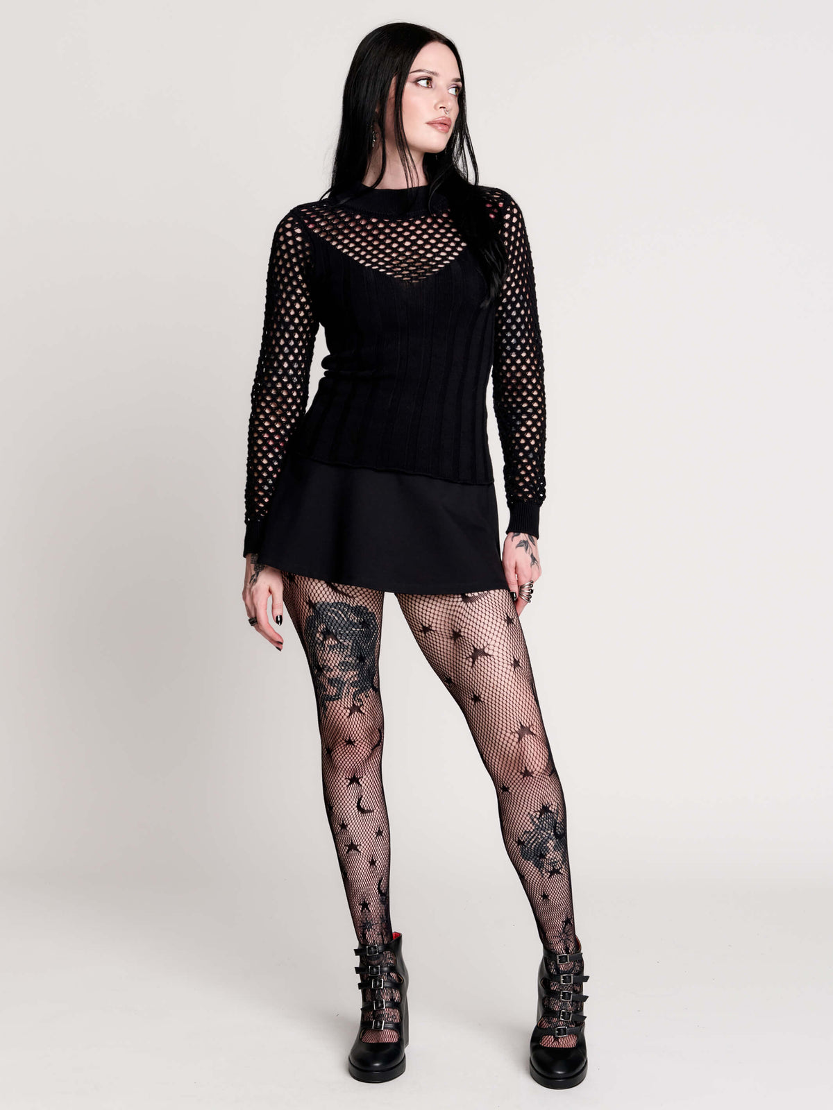 Fishnet Sweetheart Rib Sweater, a black long-sleeve top with a fitted rib-knit body and fishnet across the upper chest, shoulders, upper back and sleeves, giving a  “sweetheart” illusion while keeping the sleek silhouette sleek.