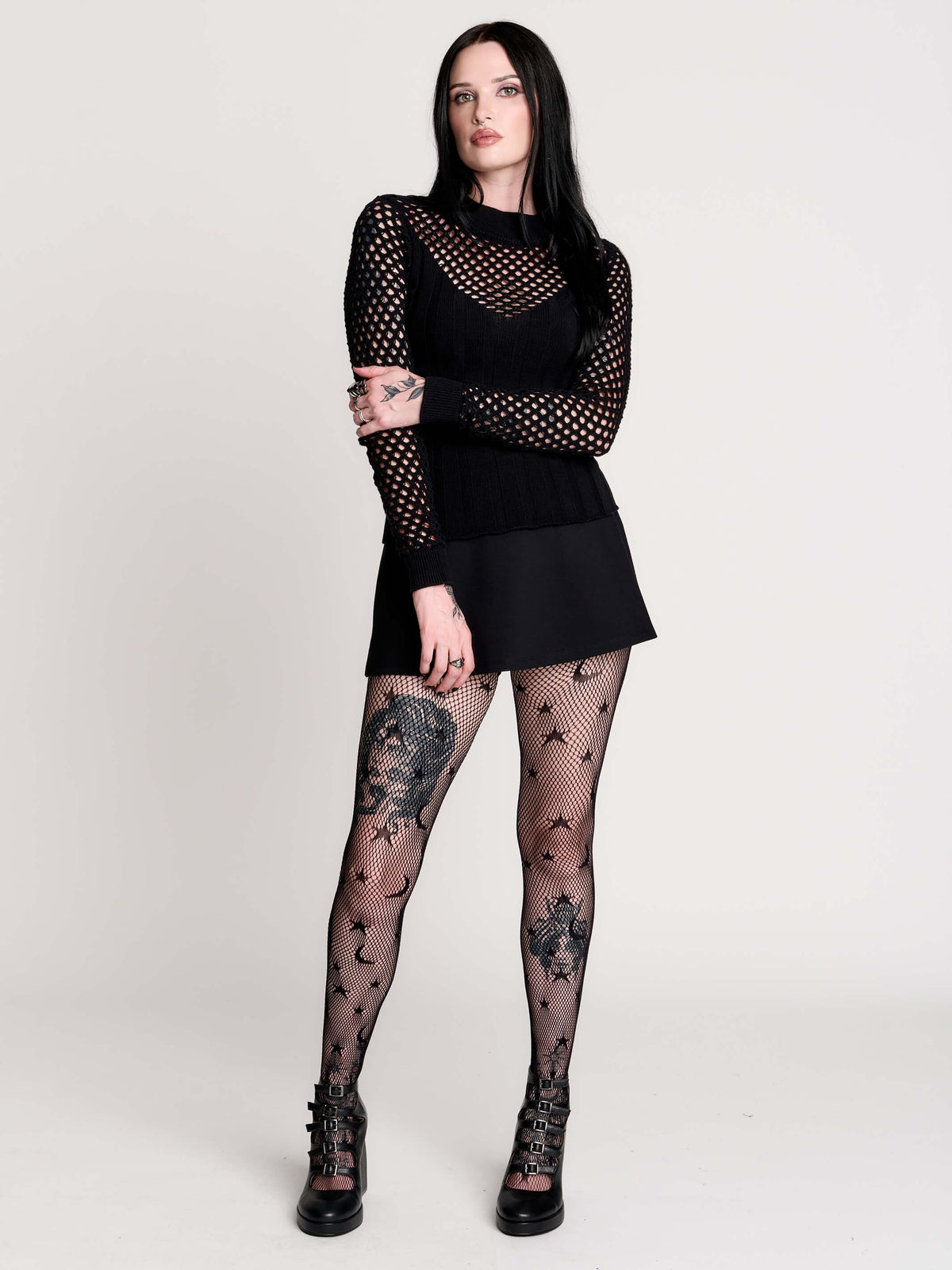 Fishnet Sweetheart Rib Sweater, a black long-sleeve top with a fitted rib-knit body and fishnet across the upper chest, shoulders, upper back and sleeves, giving a  “sweetheart” illusion while keeping the sleek silhouette sleek.