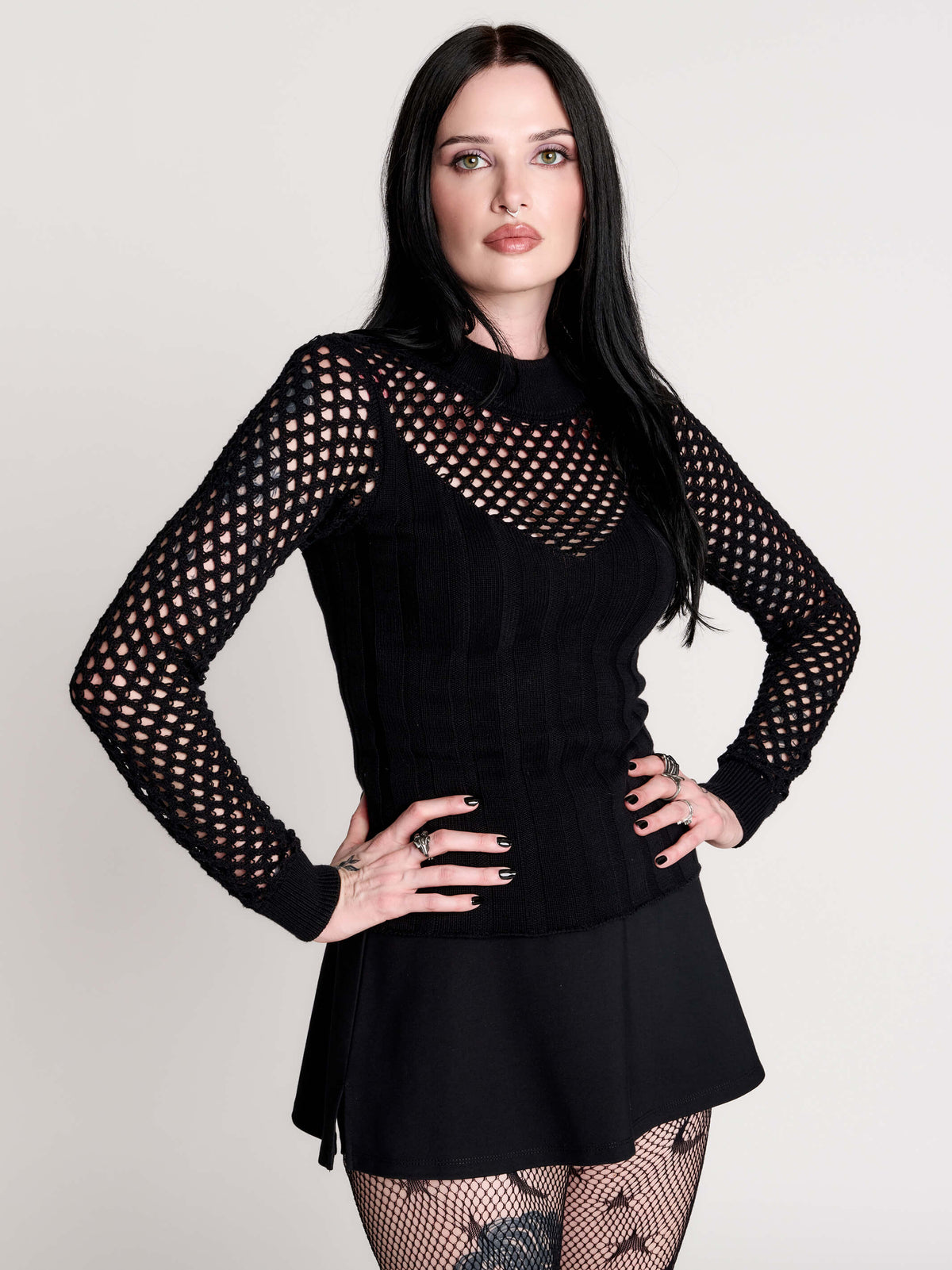 Fishnet Sweetheart Rib Sweater, a black long-sleeve top with a fitted rib-knit body and fishnet across the upper chest, shoulders, upper back and sleeves, giving a  “sweetheart” illusion while keeping the sleek silhouette sleek.