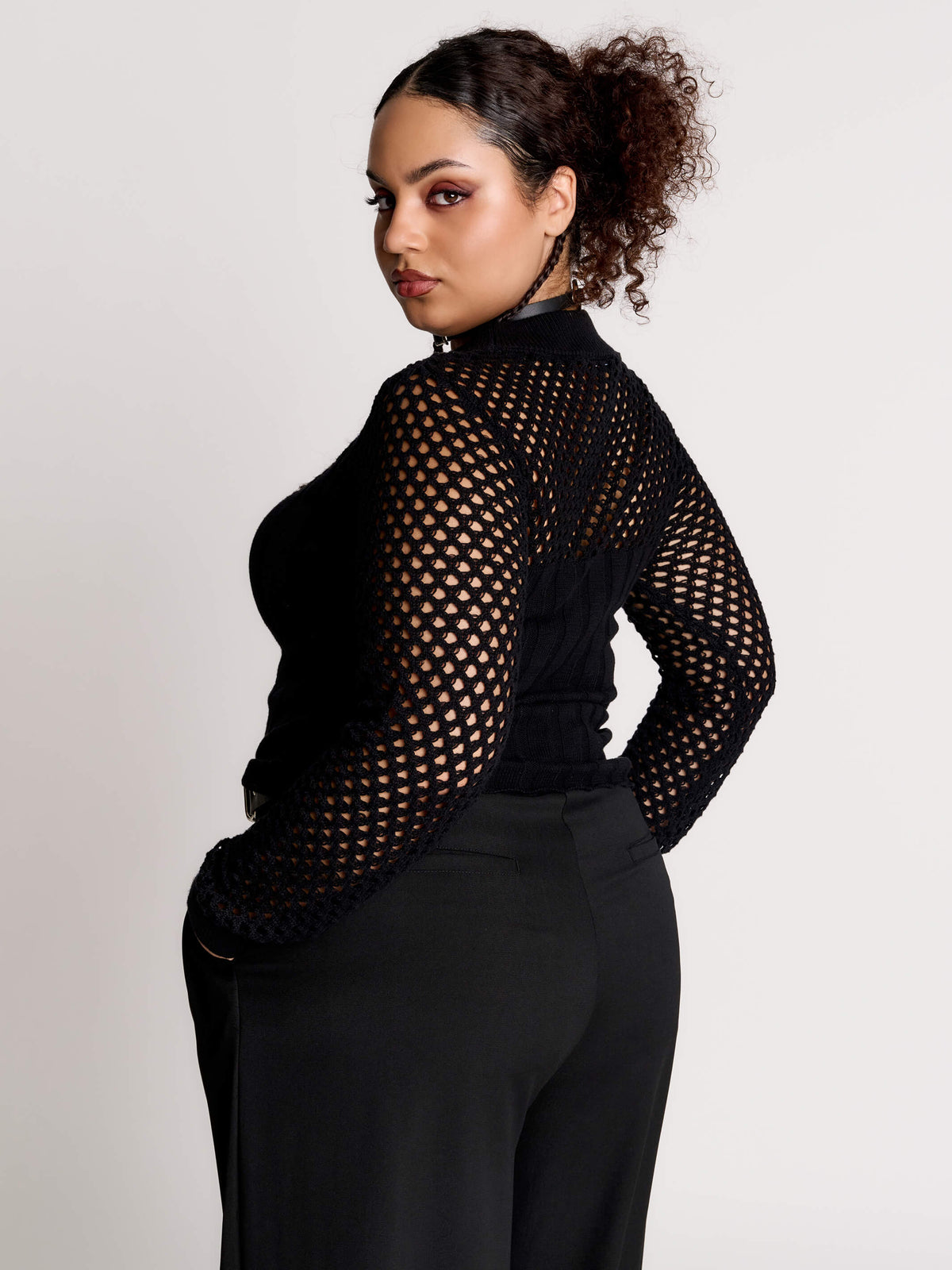 Fishnet Sweetheart Rib Sweater, a black long-sleeve top with a fitted rib-knit body and fishnet across the upper chest, shoulders, upper back and sleeves, giving a  “sweetheart” illusion while keeping the sleek silhouette sleek.