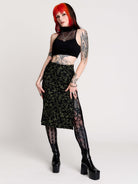 a black midi skirt with a green forest findings print. 