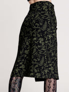 a black midi skirt with a green forest findings print. 