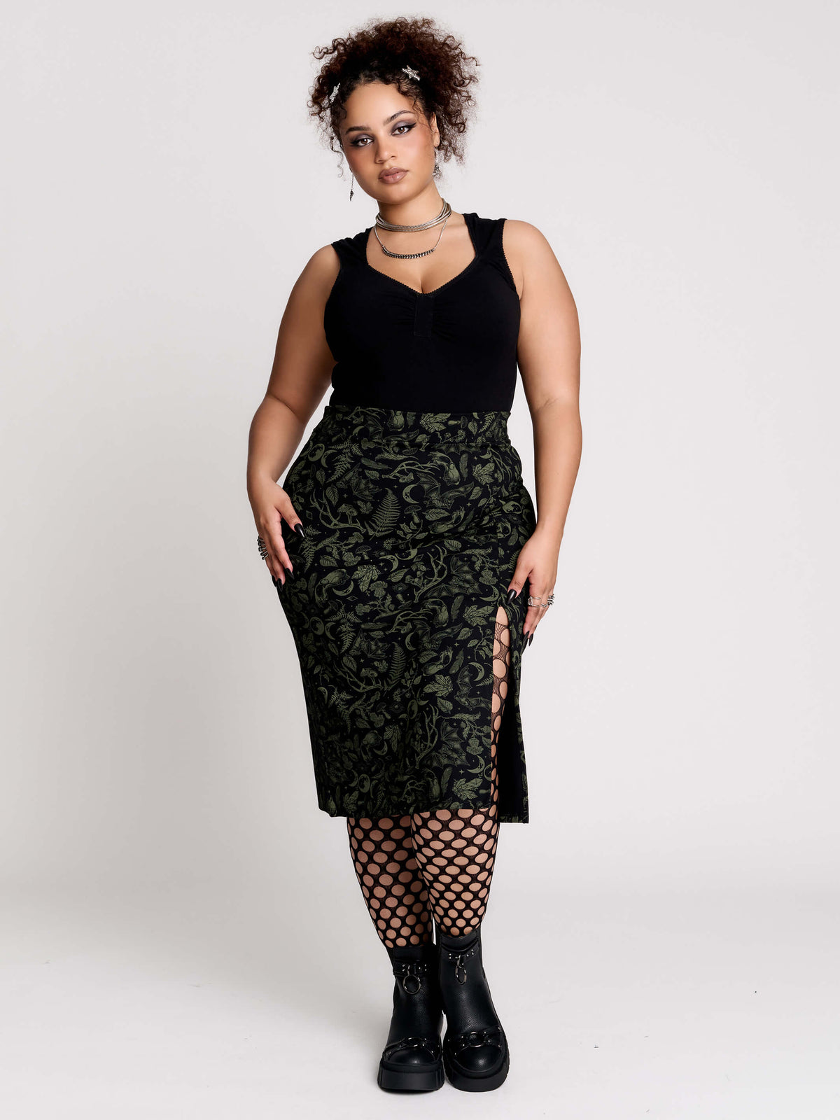 a black midi skirt with a green forest findings print. 