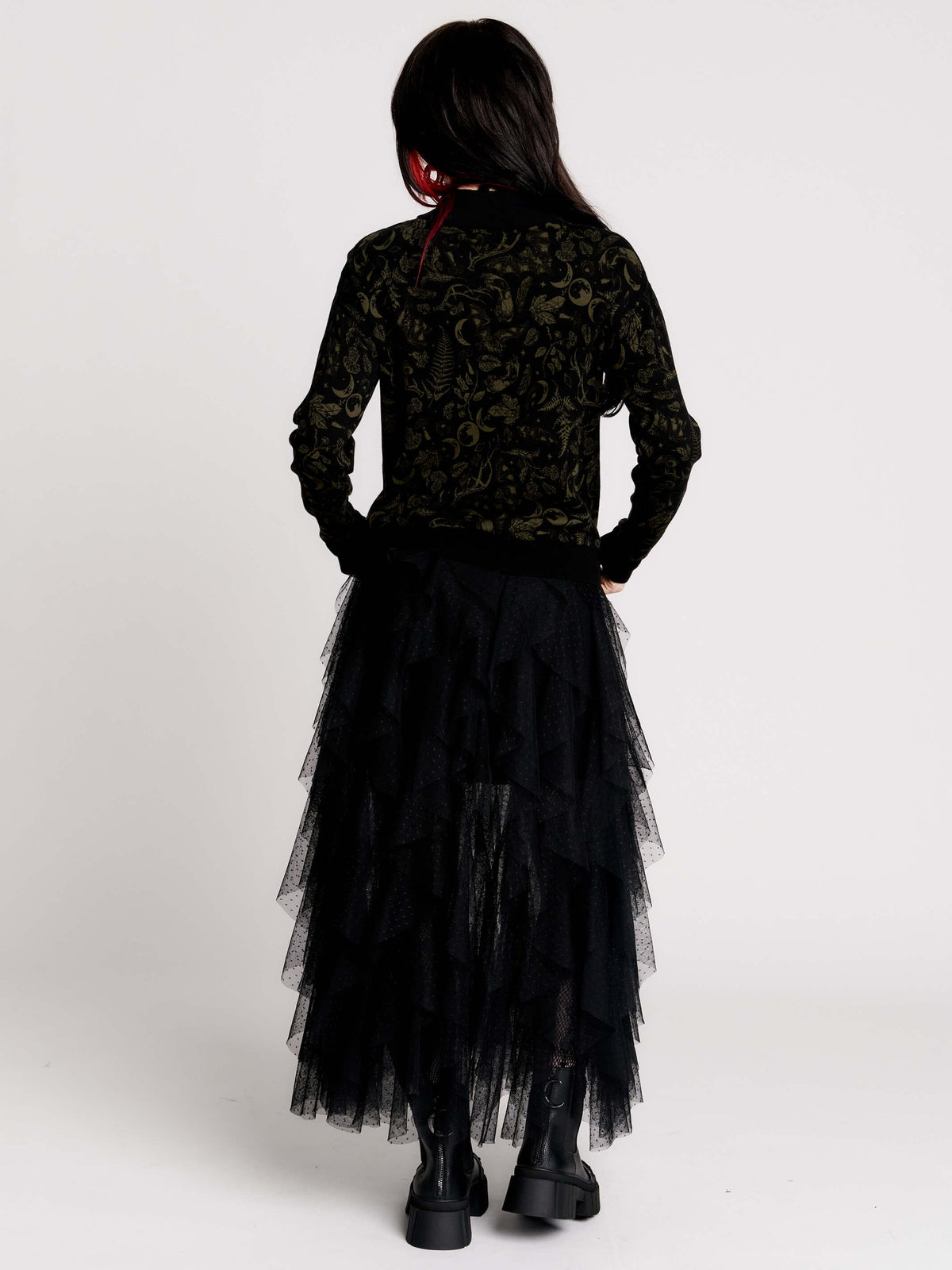 a black long-sleeve top with an intricate olive green forest findings pattern