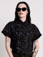 Armory Cropped Shirt is a boxy, cropped, short-sleeve button-down that mixes crisp classic shirting with dark, gothic illustration. 