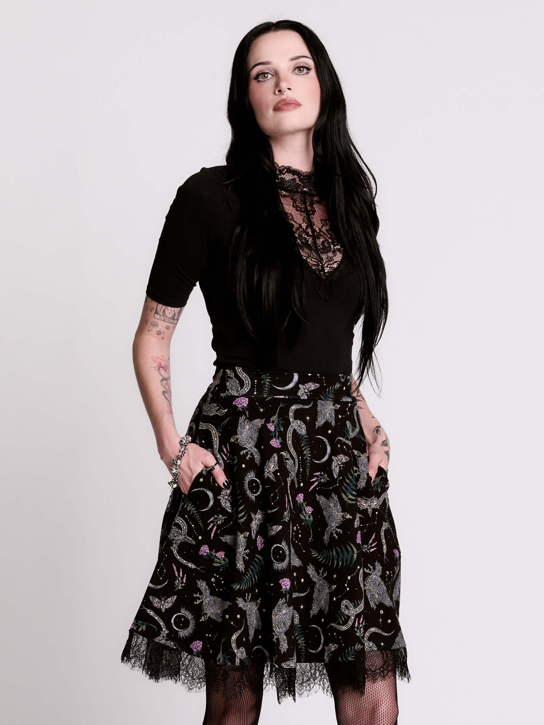 A  black flared skirt featuring a gray and purple gothic print with lace hem.