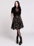 A  black flared skirt featuring a gray and purple gothic print with lace hem.