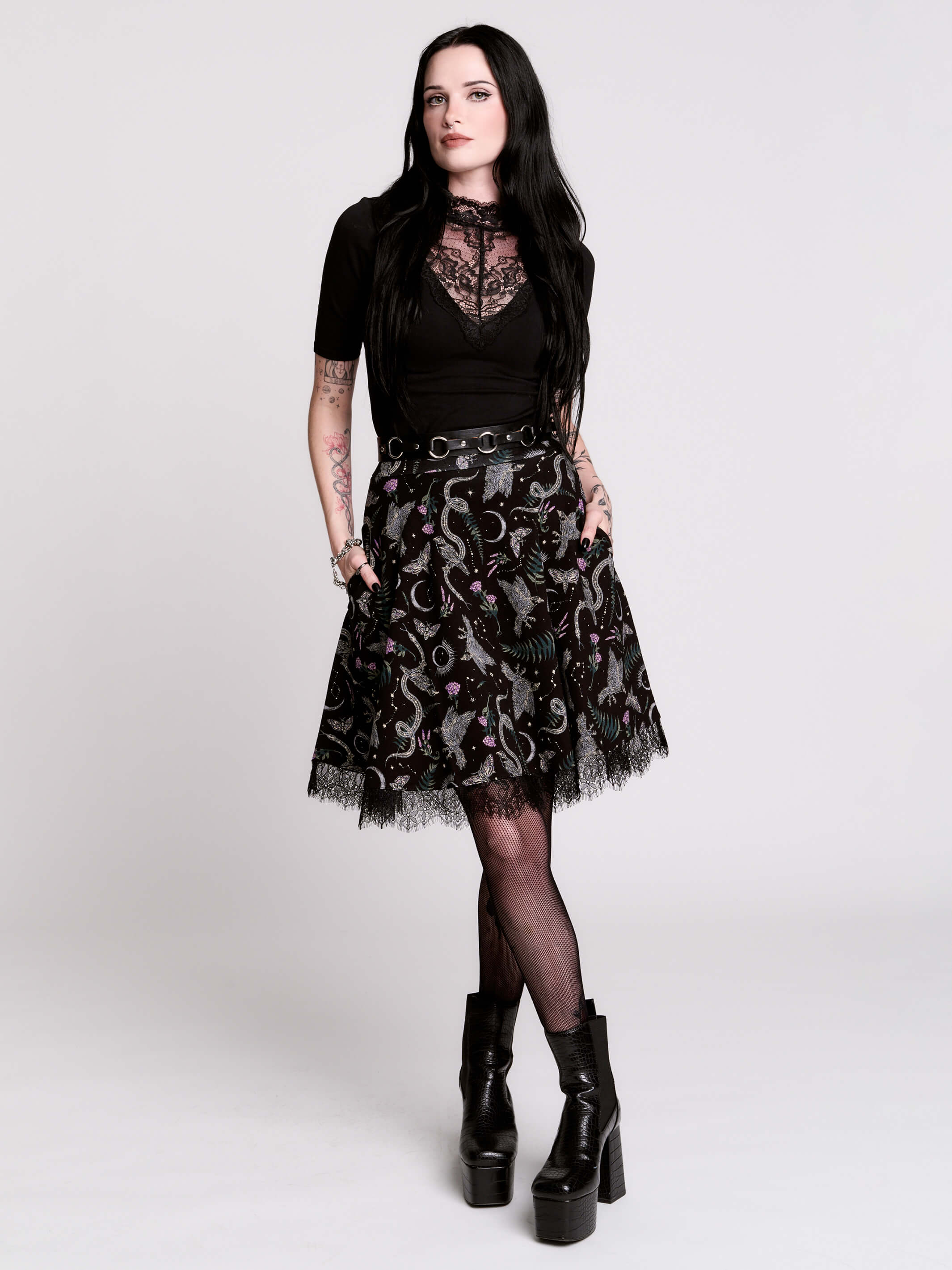 A  black flared skirt featuring a gray and purple gothic print with lace hem.