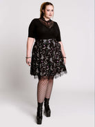 A  black flared skirt featuring a gray and purple gothic print with lace hem.