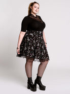 A  black flared skirt featuring a gray and purple gothic print with lace hem.