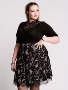 A  black flared skirt featuring a gray and purple gothic print with lace hem.