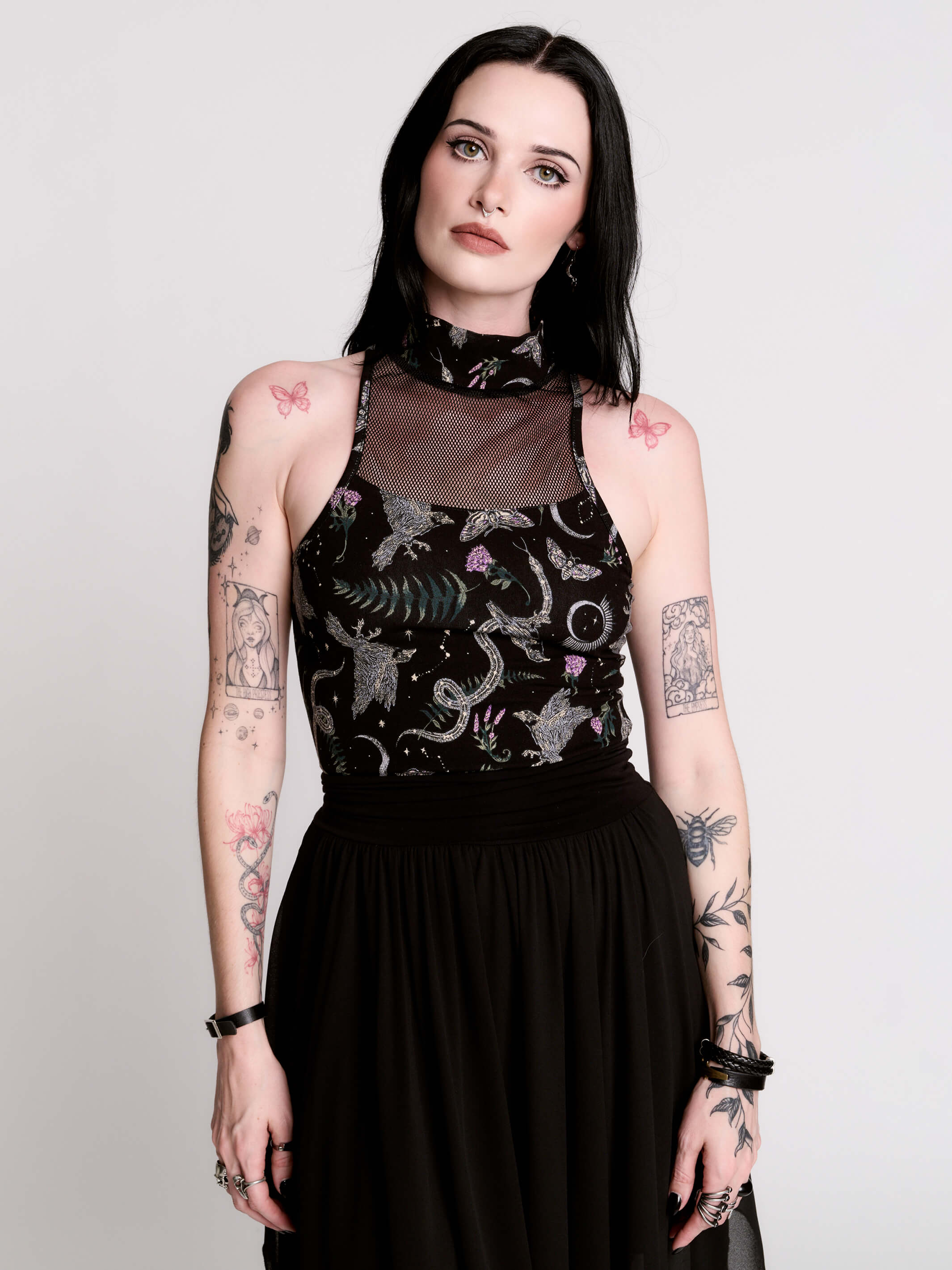 A black sleeveless top with a high mesh neck and an allover gothic-style print featuring silver snakes, moths, ravens and small pink floral accents.