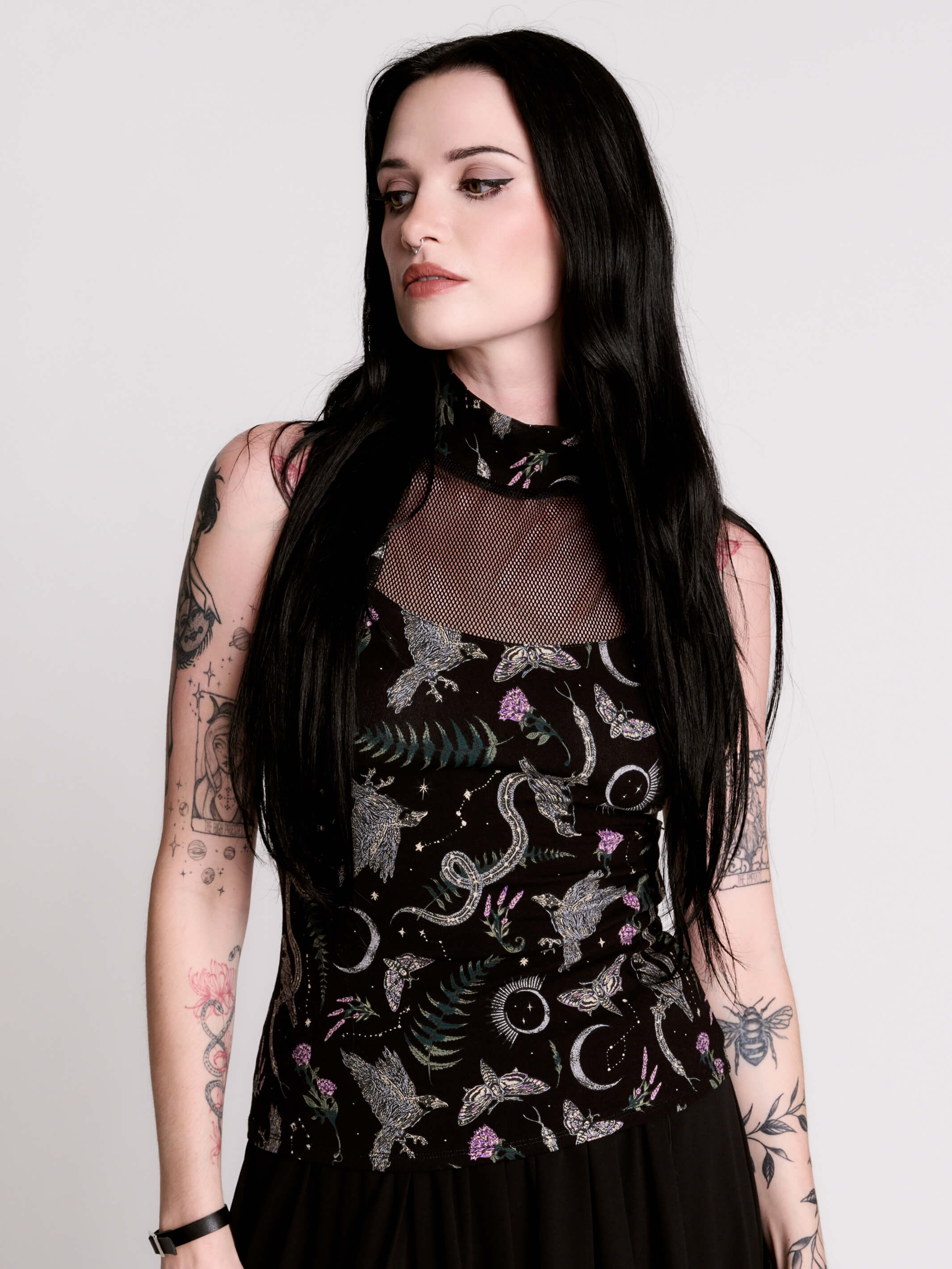 A black sleeveless top with a high mesh neck and an allover gothic-style print featuring silver snakes, moths, ravens and small pink floral accents.