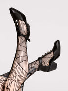 A pair of black leather ankle-strap block-heel shoes with pointed toes and silver pyramid stud embellishments.