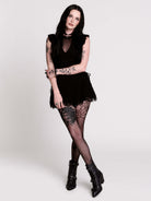 A black ruffled sleeveless top with a sheer chest cutout.