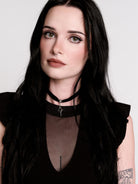 A black ruffled sleeveless top with a sheer chest cutout.