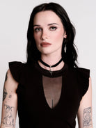 A black ruffled sleeveless top with a sheer chest cutout.