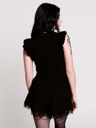 A black ruffled sleeveless top with a sheer chest cutout.