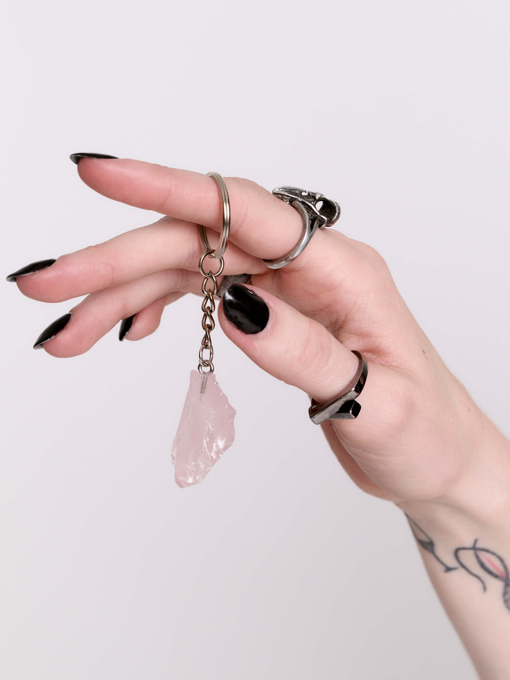 A silver keychain featuring a raw pink crystal pendant.