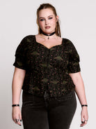 A short-sleeve button-up blouse featuring a dark green and black gothic pattern with pink accents.