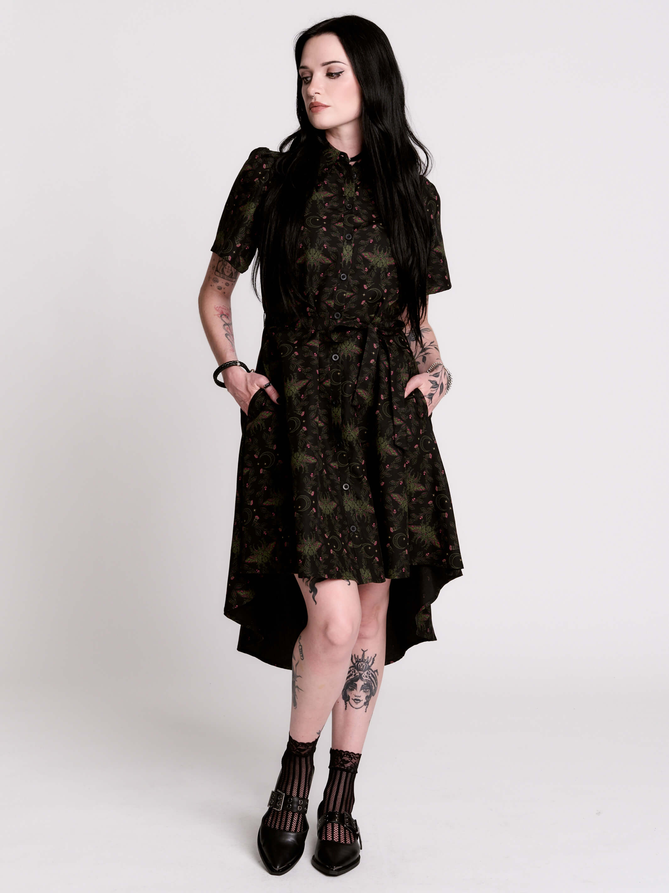 a short-sleeved high-low dress in black with a small red and green floral pattern.