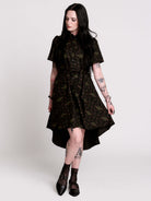 a short-sleeved high-low dress in black with a small red and green floral pattern.