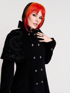 a black double-breasted coat with silver buttons and gothic dragon embroidery on the shoulder cape