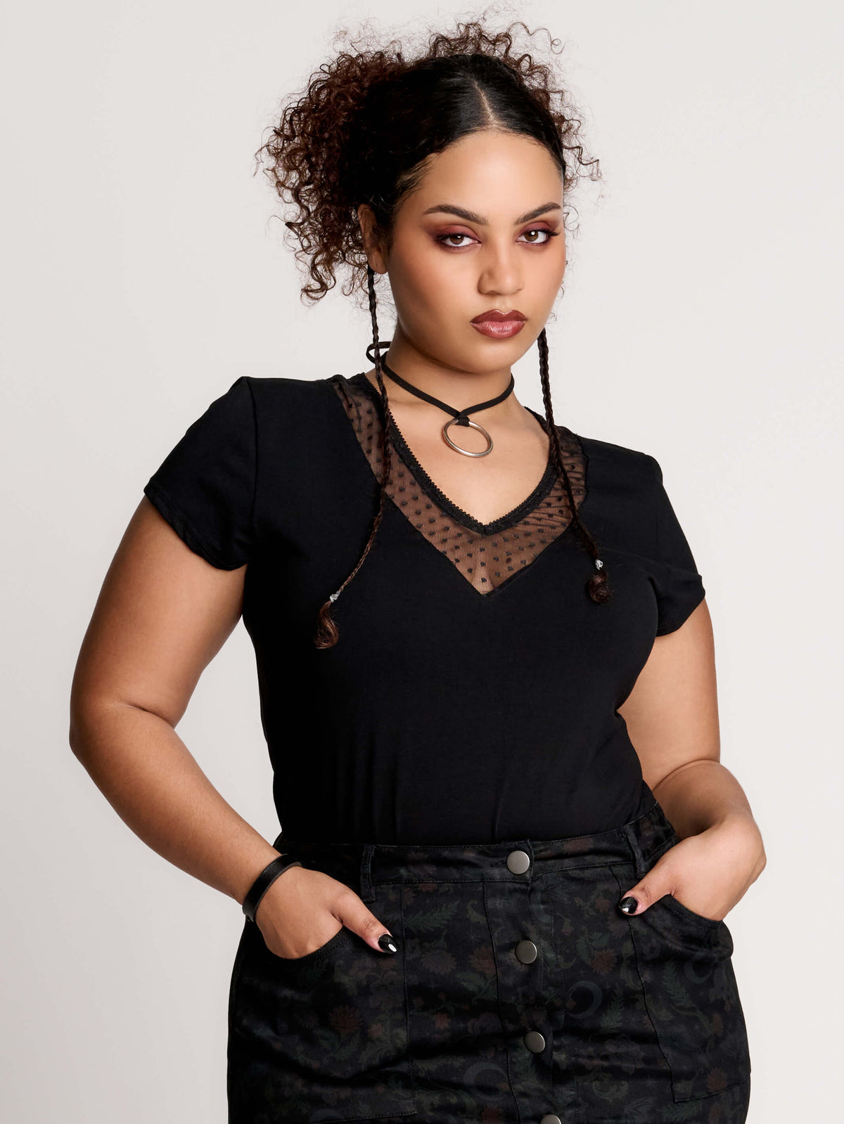 a black short-sleeve V-neck t-shirt featuring a sheer polka-dot mesh panel at the neckline