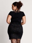 a black short-sleeve V-neck t-shirt featuring a sheer polka-dot mesh panel at the neckline