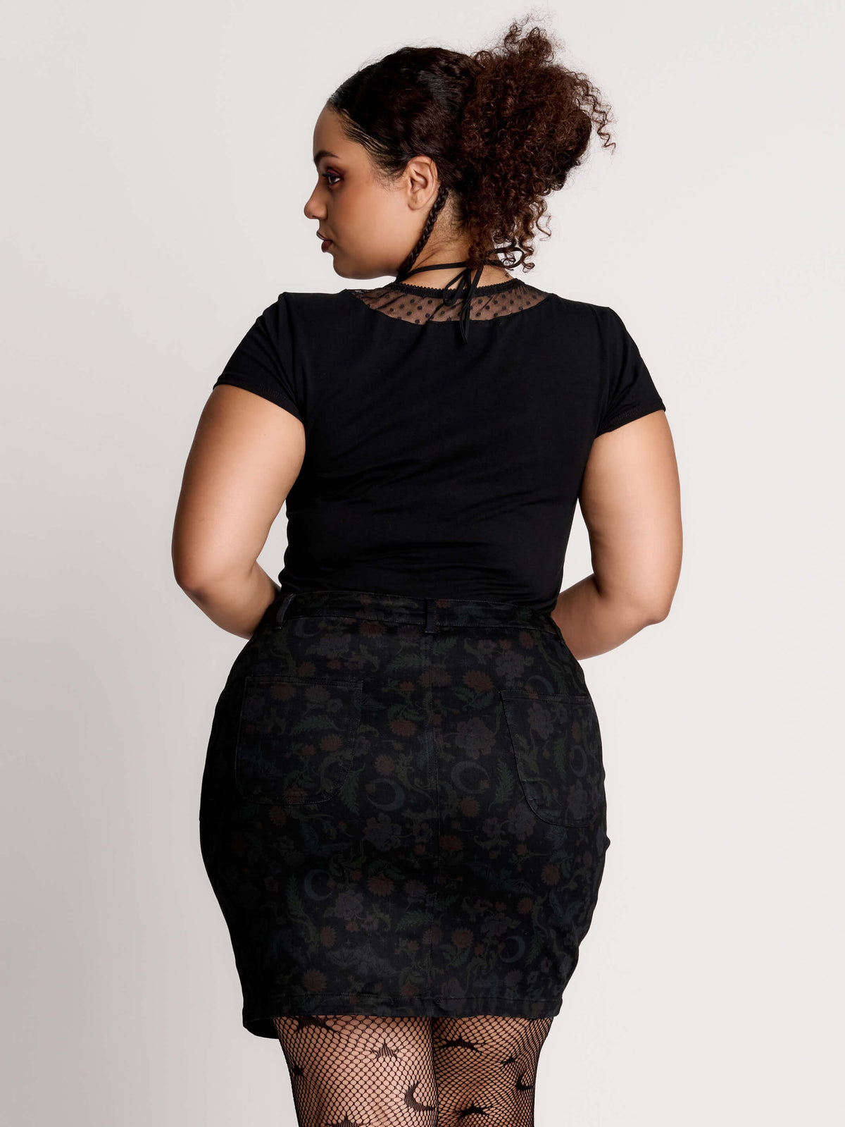 a black short-sleeve V-neck t-shirt featuring a sheer polka-dot mesh panel at the neckline