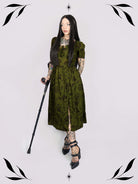 a short-sleeved olive green midi dress with a gothic pattern